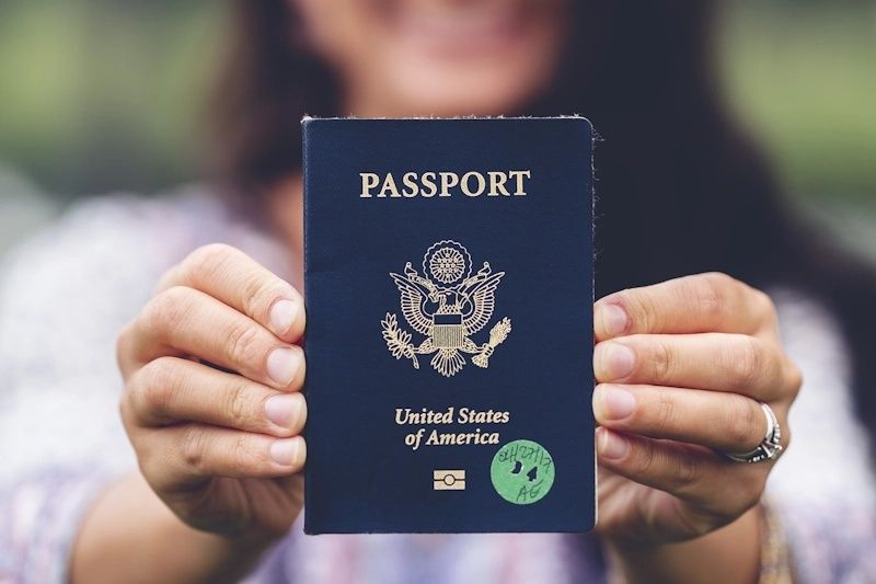 Person håller upp ett amerikanskt pass framför kameran